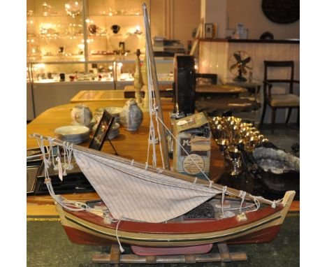 A painted model sloop on a stand