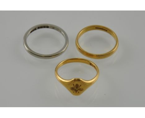 Two 18ct yellow and white gold bands together with an 18ct signet ring embossed with a bee, total 8.9g