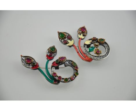 A pair of silver enamel brooches set with red and green stones