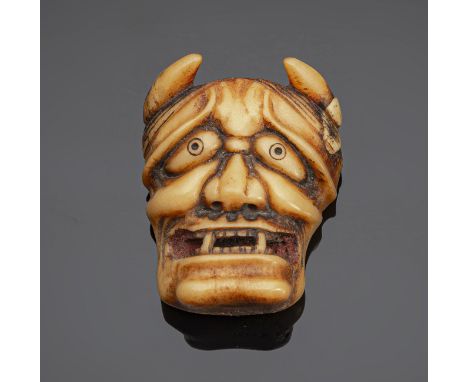 Netsuke einer Hannya-Maske aus HirschhornJapan, 19. Jh.H. 5 cmDie Hanny-Maske mit grimmigem Gesichtsausdruck und geöffnetem M