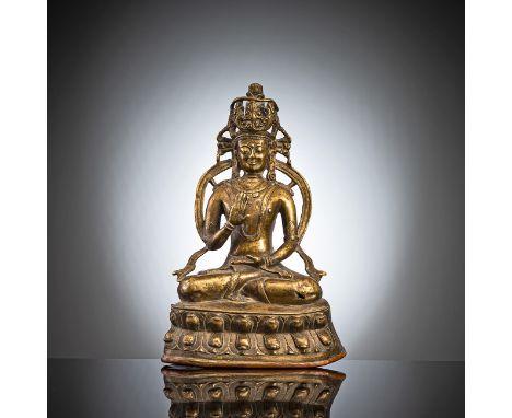 Bronze des AmoghasiddhaTibet, 15. Jh.H. 21,5 cmIn vajrasana auf einem Lotussockel sitzend, die rechte Hand in Abhayamudra, wä