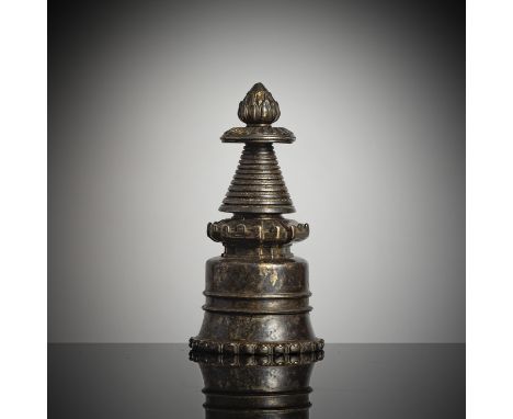 Stupa aus BronzeTibet, ca. 14. Jh.H. 15 cmDer Stupa mit einem gewölbten Körper, der mit einem doppelten horizontalen Grat ver