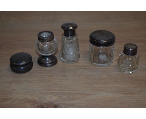 A collection of cut glass scent and dressing table jars, with silver and white metal mounts/lids, and two sets of gilt metal 