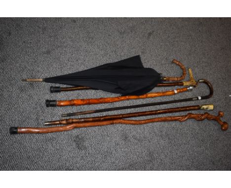 A collection of walking sticks and parasol, to include silver-mounted walking stick, horn handled sticks, and a knotted wood 