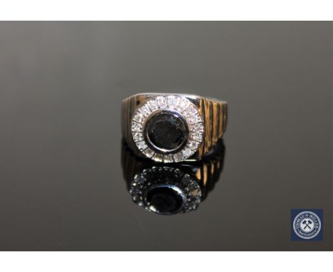 A 14ct white gold diamond cluster ring, the central brilliant-cut, colour-enhanced black diamond weighing 1.48 carat, within 