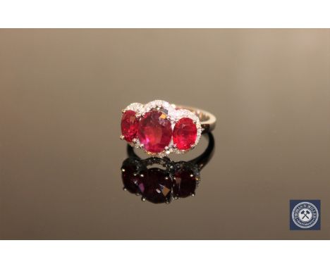 A 14ct white gold ruby and diamond ring, three oval-cut deep red rubies weighing a total of 5.44 carats within claw settings,