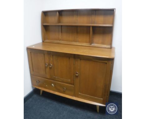 An Ercol elm triple door sideboard with display rack 