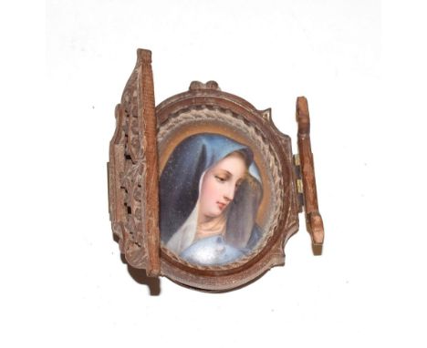 A 19th century painted porcelain portrait miniature of the Virgin Mary, unsigned, within a pierced carved wooden frame, overa