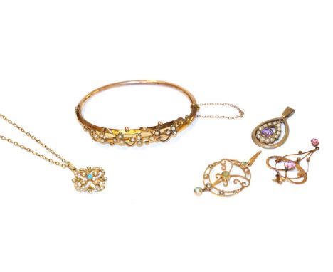 A collection of Edwardian jewellery including a hinged seed pearl bangle, of foliate design; a 9 carat gold amethyst pendant;