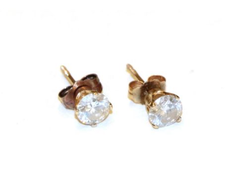 A pair of diamond solitaire earrings, the round brilliant cut diamonds in yellow claw settings, total estimated diamond weigh