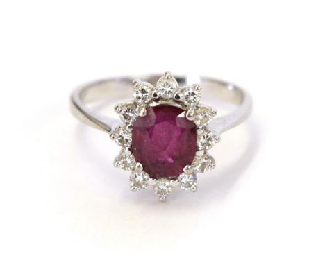 A synthetic ruby and diamond cluster ring, the oval cut synthetic sapphire within a border of round brilliant cut diamonds, i