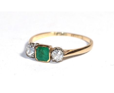 An emerald and diamond three stone ring, the emerald-cut emerald in a yellow rubbed over setting flanked by two old cut diamo