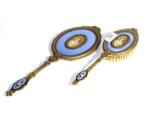 A brass-mounted and enamel hand-mirror and hair-brush, each with light purple enamel and an oval printed portrait of a lady, 