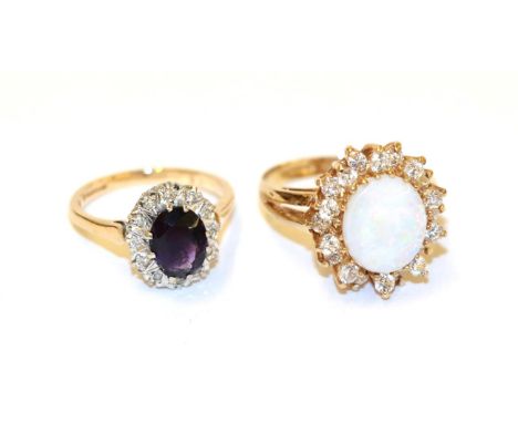 A 9 carat gold amethyst and diamond cluster ring, the oval cut amethyst within a border of eight-cut diamonds, in white claw 