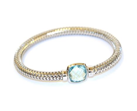 A blue topaz bangle, the white expanding snake link bangle with a fancy cut blue topaz centrally, in a rubbed over setting, i