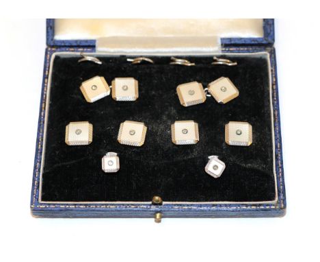 A cased Art Deco mother-of-pearl and diamond dress stud and cufflink suite, comprising four buttons, two studs and a pair of 