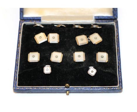 A cased Art Deco mother-of-pearl and diamond dress stud and cufflink suite, comprising four buttons, two studs and a pair of 