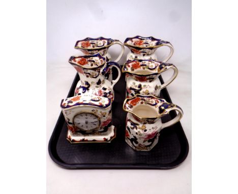 A tray containing five Masons Mandalay jugs together with a matching mantel clock. 