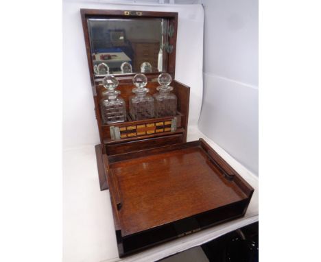 A 19th century oak three-bottle decanter box containing internal drawers, cribbage board, playing cards, King Edward invincib