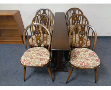 An Ercol solid elm and beech drop leaf table together with set of six Fleur de Lys dining chairs 