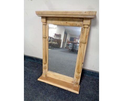 A stripped pine hall mirror with shelf.