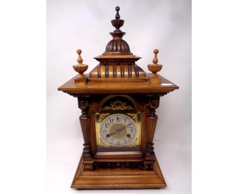 An Edwardian walnut cased mantel clock with brass dial