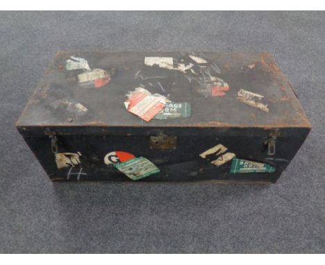 An antique tin shipping trunk bearing labels 