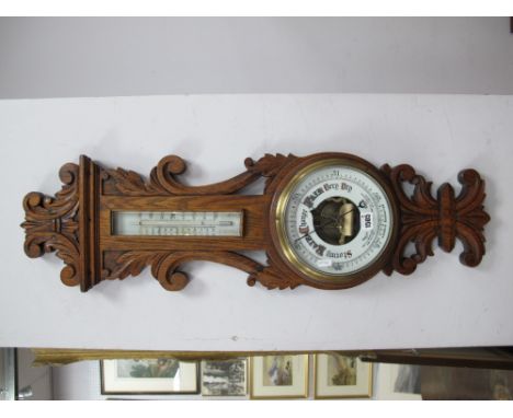 An Oak Carved Wall Barometer, with thermometer to neck (some damage) 91cm high.