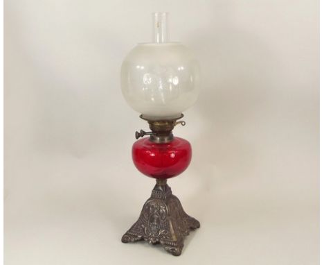 OIL LAMP.
A Victorian oil lamp with red glass fount & cast iron base. Height 59cm.
PLEASE NOTE:  Our in-house, postal shippin