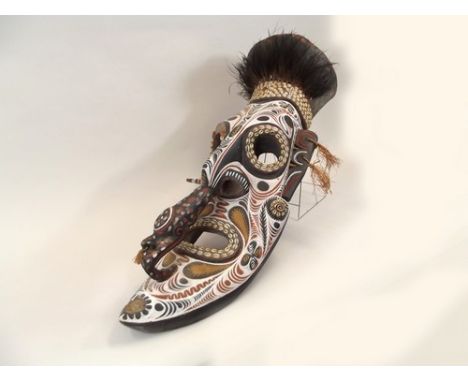 AFRICAN MASK.
A large African painted mask set with cowrie shells and ostrich feathers. Length 95cm.
PLEASE NOTE:  Our in-hou