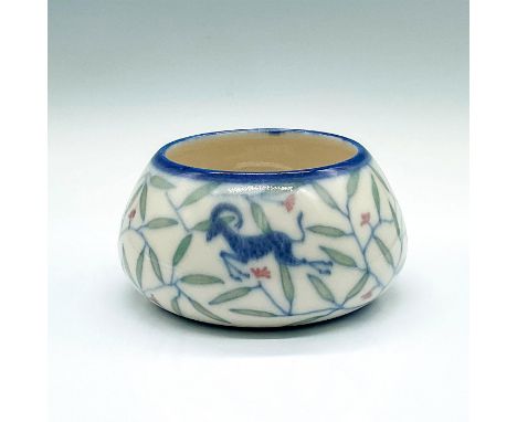 A beautiful glaze painted vase; decorated with a white ground and blue trim. Depicts blue oryxes leaping through green leaves