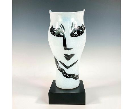 Beautiful glass vessel with head shape and stylized facial features. Handblown and hand decorated vessel that sits on a squar
