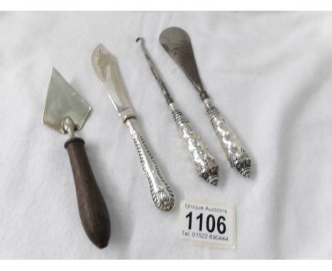 A matching silver handled button hook and shoe horn together with a silver handled butter knife and a small silver trowel.