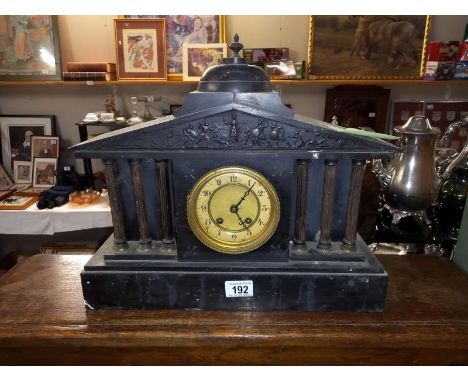 A black slate mantle clock with 6 brass reeded columns, no key, no pendulum, 1 spring broken 1 over wound