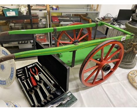 A vintage painted wooden scale model of a hand cart.