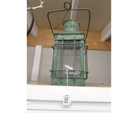 A green painted metal candle lantern.