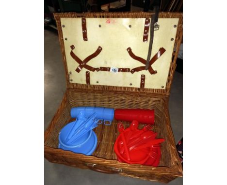 A wicker picnic hamper with contents
