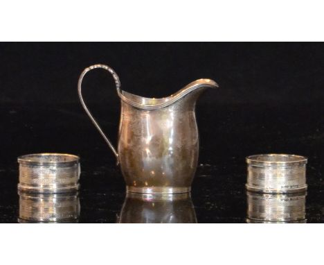 A hallmarked silver cream jug of plain form with reeded rim and acanthus leaf scroll handle, Chester 1906, George Nathan and 