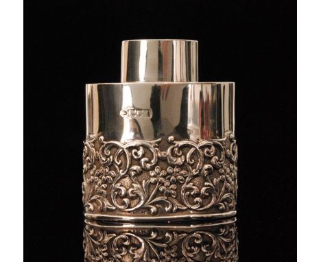 A George V hallmarked silver tea caddy of ovoid form with part chased and embossed foliate decoration and plain pull off cove
