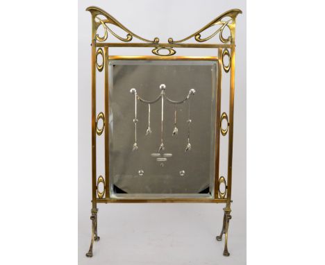 An Art Nouveau mirrored brass firescreen on swept open end supports, width 46cm