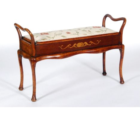 An early 20th Century stained beech duet piano stool, with twin side rails and lift-up seat above inlaid foliate detail to th