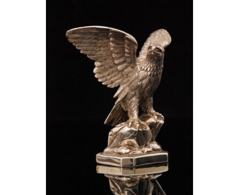 A modern hallmarked silver model of an eagle, modelled with outspread wings, looking to the right and perched on a rocky base