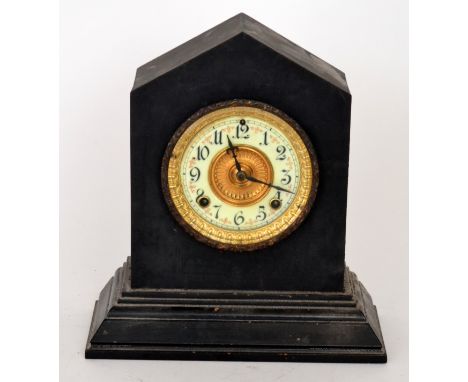 A late Victorian mantel clock of apex form raised to a stepped rectangular base with a central enamel dial with gilded chapte