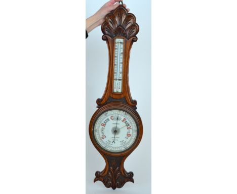 A Victorian carved oak aneroid barometer, the circular enamelled dial below a thermometer by H Salanson and Company Bristol, 