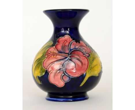 A Moorcroft vase of globe and shaft form decorated in the Hibiscus pattern with tubelined flowers and foliage against a blue 