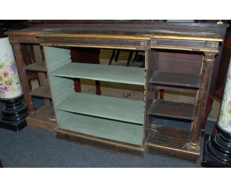 A Regency style simulated rosewood and parcel gilt breakfront bookcase, fixed side shelves with turned doric columns on a pli