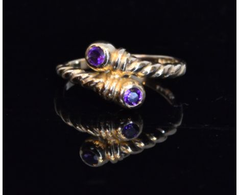 A 9ct Roman style amethyst two stone ring, torque style ring with twist detail and single amethyst to each terminal, ring siz