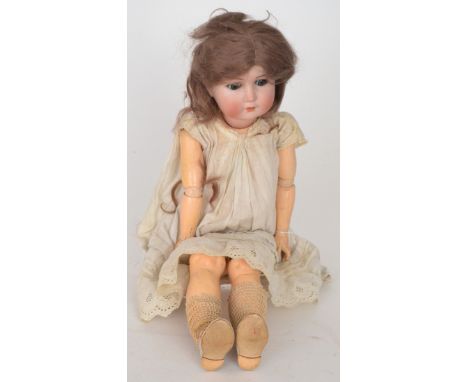 A German Goebels bisque head doll, open close eyes and mouth, jointed composition body, wearing an embroidered dress and leat