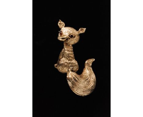 A 14ct yellow gold brooch modelled as a fox, with ruby eyes and swirling bushy tail, length 5.2cm, weight 11g