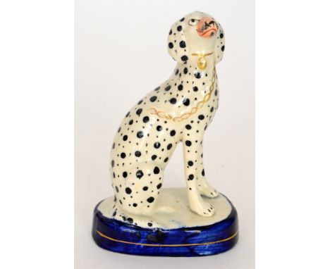 A 19th Century Staffordshire model of a seated Dalmatian with gilt collar and chain, raised to a blue oval plinth, height 13.